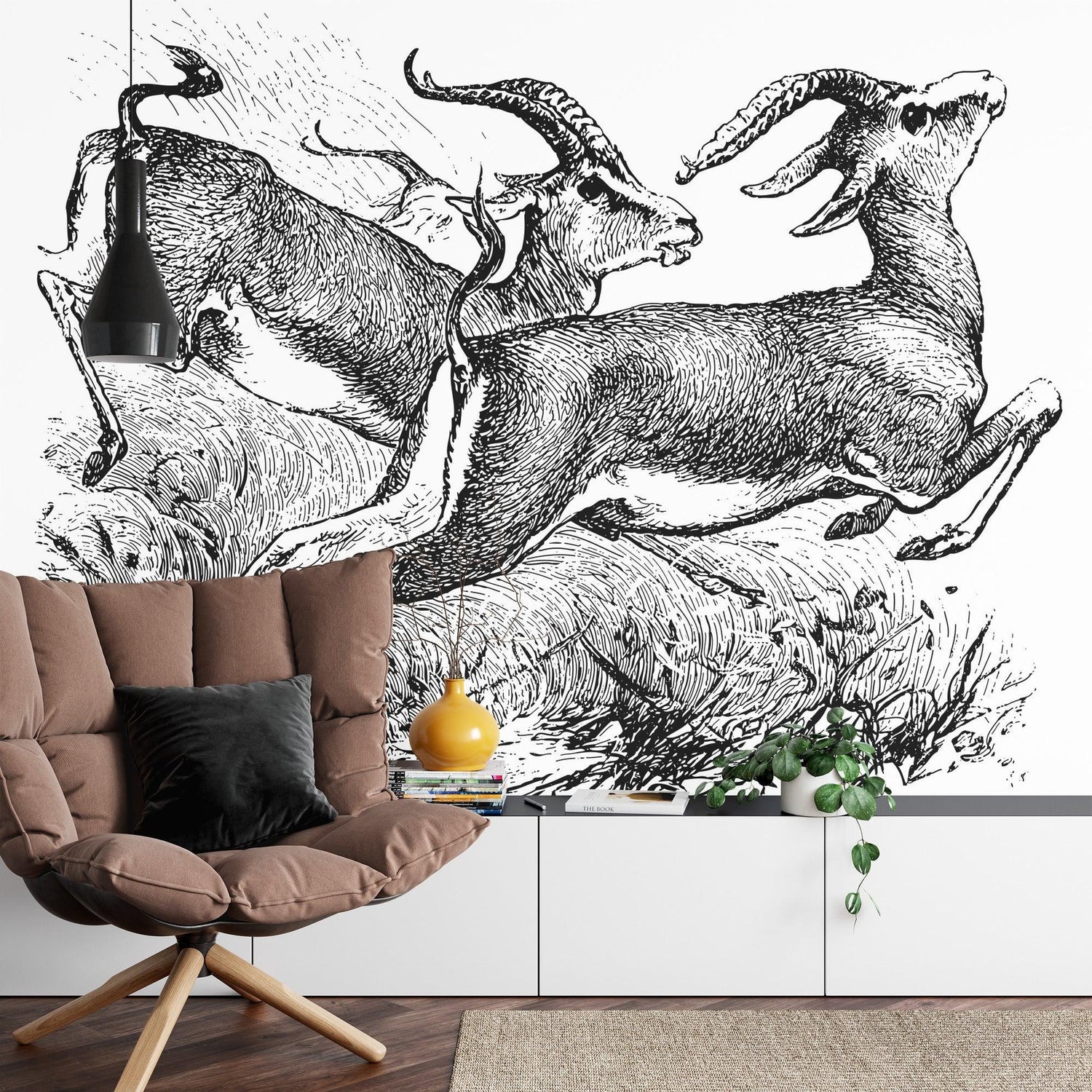 Black and white gazelle sketch mural adding drama to dining room with wooden table and pendant lights
