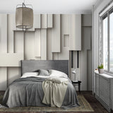 Modern 3D geometric wallpaper adding depth to a minimalist living room with grey sofa and natural light