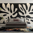 Modern black and white foliage wallpaper creating dramatic contrast in a minimalist living room setting