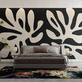 Modern black and white foliage wallpaper creating dramatic contrast in a minimalist living room setting