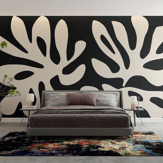 Modern black and white foliage wallpaper creating dramatic contrast in a minimalist living room setting