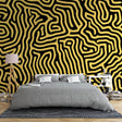 Modern living room featuring Black and Gold Geometric Maze wallpaper creating a stunning accent wall behind grey sofa