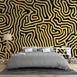 Modern living room featuring Black and Gold Geometric Maze wallpaper creating a stunning accent wall behind grey sofa