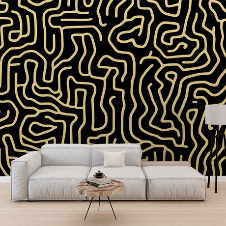 Black and gold maze pattern wallpaper creating depth in a modern living room with soft ambient lighting