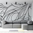 Abstract line art wallpaper creating dramatic impact in a modern living room with minimalist furniture