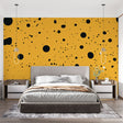 Modern home office featuring yellow and black polka dot wallpaper creating an energetic workspace atmosphere