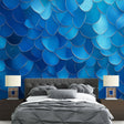Modern blue metallic scale wallpaper creating depth in a minimalist living room with natural light