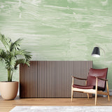 Sage green brushstroke wallpaper in home office setting with wooden desk