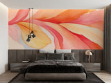 Home office space with orange abstract wall mural creating energetic workspace