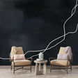 Modern abstract line wallpaper creating dramatic contrast in a minimalist living room with white furniture