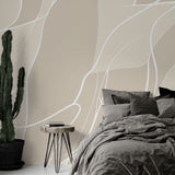 Abstract line wallpaper creating a serene atmosphere in a modern minimalist living room with beige and white flowing patterns