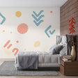 Modern pastel geometric wallpaper in a bright home office showing soft pink and blue shapes creating a fresh workspace atmosphere