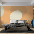 Modern geometric abstract wallpaper with peach and navy circles shown in a bright contemporary living room setting