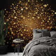 Black and gold abstract wallpaper creating dramatic impact in modern living room with floating golden spheres catching light