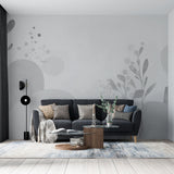 Modern grey abstract floral wallpaper creating a serene atmosphere in a minimalist living room with natural light