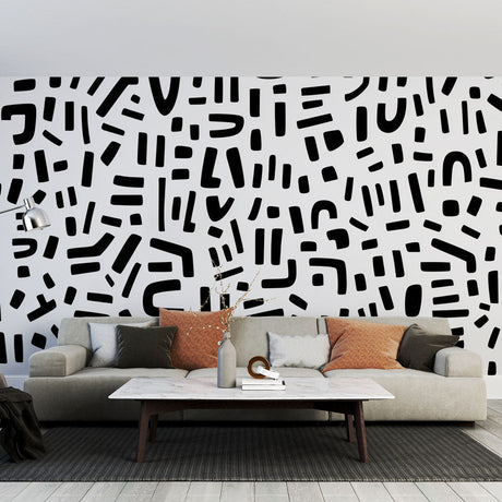 Modern abstract black and white geometric wallpaper in a minimalist living room setting with natural light