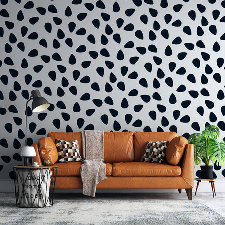 Modern black drops pattern wallpaper in a bright minimalist living room setting with clean furniture and natural light