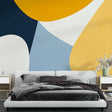 Modern geometric wallpaper with yellow and blue curves creating depth in a minimalist living room setting