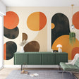 Modern geometric wallpaper with terracotta shapes creating a bold statement in a minimalist living room setting