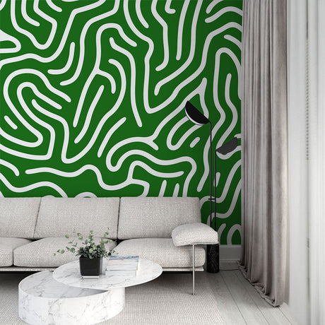 Modern green labyrinth abstract wallpaper creating depth in a bright, minimalist living room with white furniture