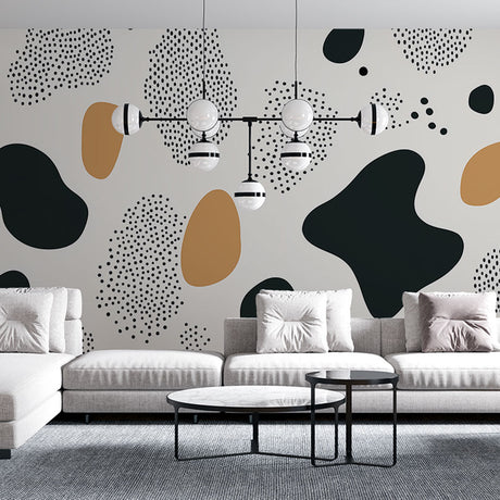 Modern abstract wallpaper with black and gold organic shapes creating a striking feature wall in a minimalist living room