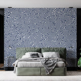 Navy blue geometric wallpaper creating a stunning focal point in a modern living room with clean furniture and natural light