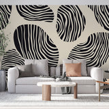 Abstract geometric wallpaper with black and white stripes showcased in a modern minimalist living room setting