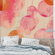 Pink geometric circle wallpaper in modern living room setting with gray sofa and natural light