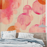 Pink geometric circle wallpaper in modern living room setting with gray sofa and natural light