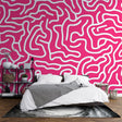 Pink geometric pattern wallpaper creating a modern statement wall in a bright, minimalist living room setting