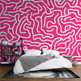 Pink geometric pattern wallpaper creating a modern statement wall in a bright, minimalist living room setting
