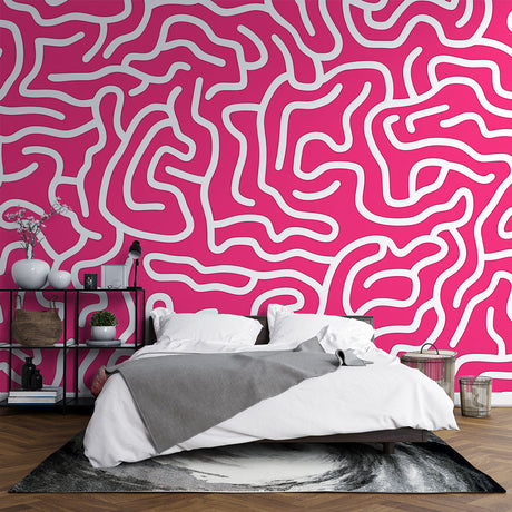 Pink geometric pattern wallpaper creating a modern statement wall in a bright, minimalist living room setting