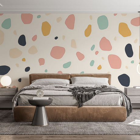 Abstract terrazzo wallpaper in soft pastels creating a modern look in a bright living room with minimal furniture