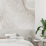 Modern living room featuring beige wave pattern wallpaper with natural lighting highlighting textured details