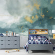 Watercolor cloud wallpaper with gold accents in a bright modern living room creating an airy atmosphere