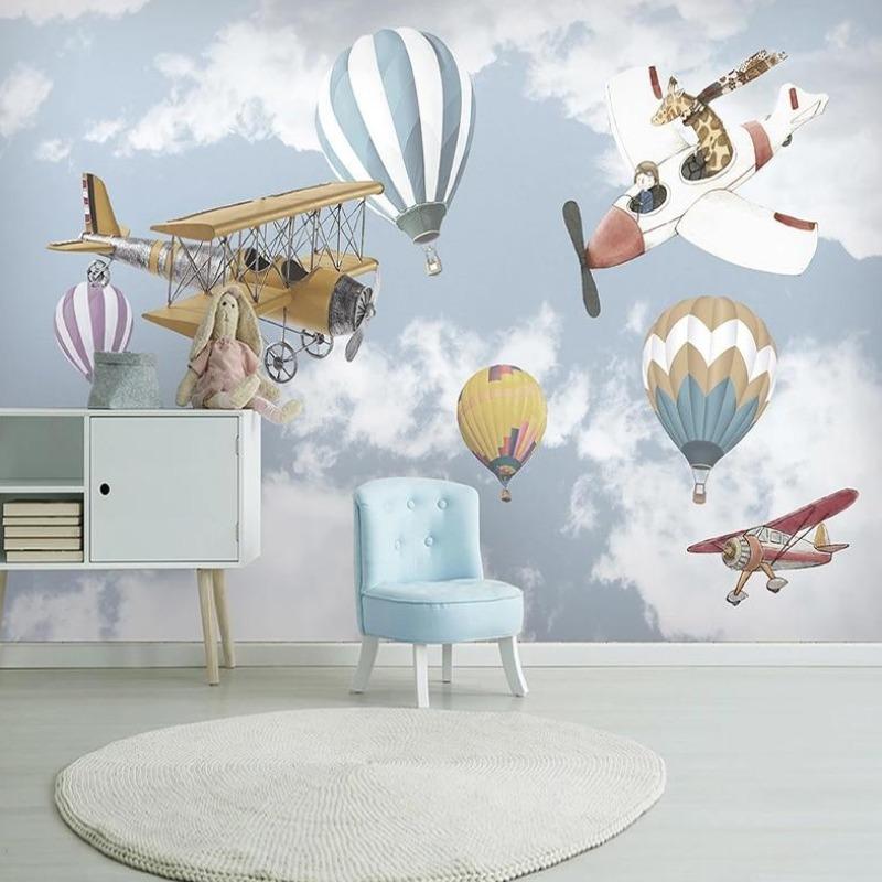 Aviation themed wallpaper in a bright nursery with white furniture, showing hot air balloons and vintage planes