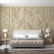 Gold geometric Art Deco wallpaper creating drama in a modern living room with high ceilings and minimal furniture