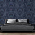 Navy blue art deco wave wallpaper creating depth in a modern dining room with ambient lighting