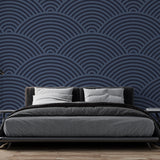 Navy blue art deco wave wallpaper creating depth in a modern dining room with ambient lighting
