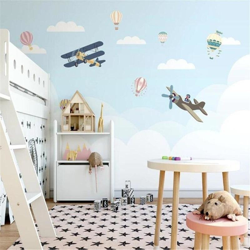 Kids bedroom transformed with airplane and hot air balloon wallpaper in soft blue tones