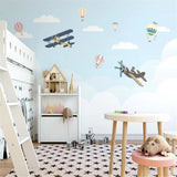 Kids bedroom transformed with airplane and hot air balloon wallpaper in soft blue tones