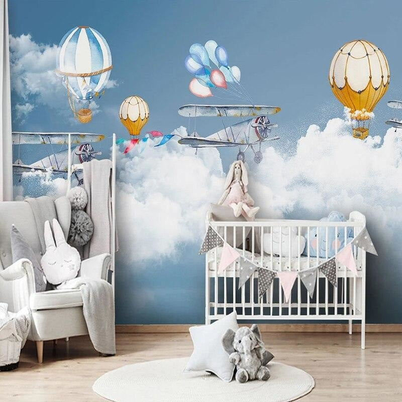Kids bedroom featuring airplane and hot air balloon wallpaper, showing playful sky design