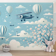 Hot air balloon wallpaper with cherry blossoms creating a magical atmosphere in a bright nursery with white furniture