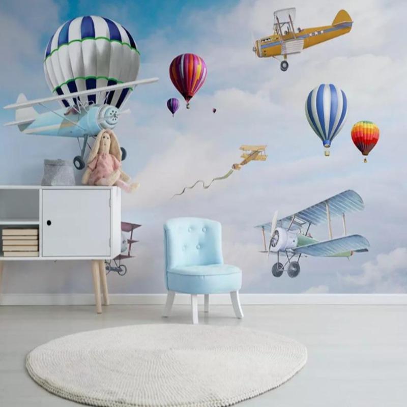 Aviation themed wallpaper in bright nursery with white furniture shows hot air balloons and vintage planes
