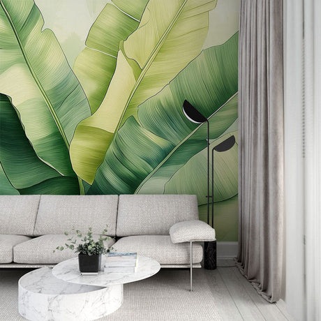 Banana leaf wallpaper creating a fresh tropical atmosphere in a modern living room with white furniture and natural light