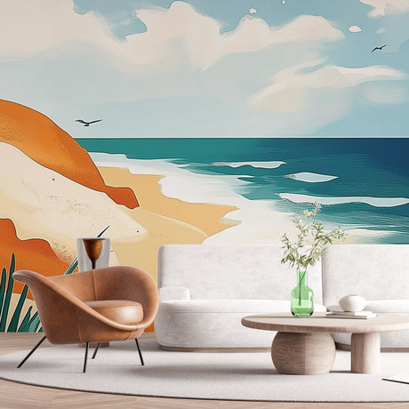 Beach mural wallpaper showing coastal cliffs and turquoise waves in a bright modern living room with white furniture