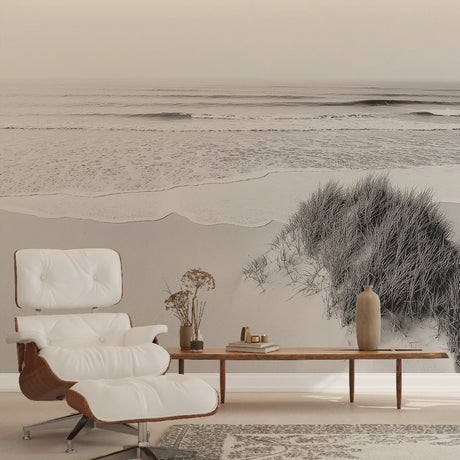 Black and white beach wallpaper creating a serene focal point in a modern living room with minimal furniture