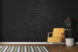 Industrial black brick mural in home office with white desk setup