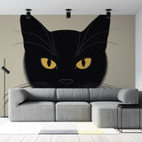 Black cat wall mural displayed in a modern living room, showing dramatic golden eyes against dark walls