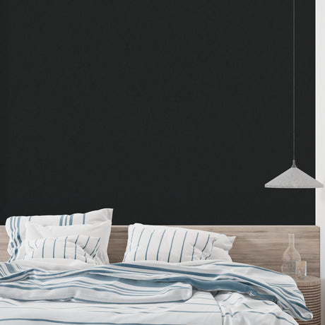 Black matte wallpaper in modern living room creating dramatic backdrop for colorful furniture